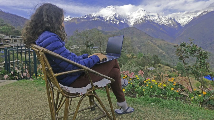 Remote worker with laptop overlooking hills and valleys near Nagarkot