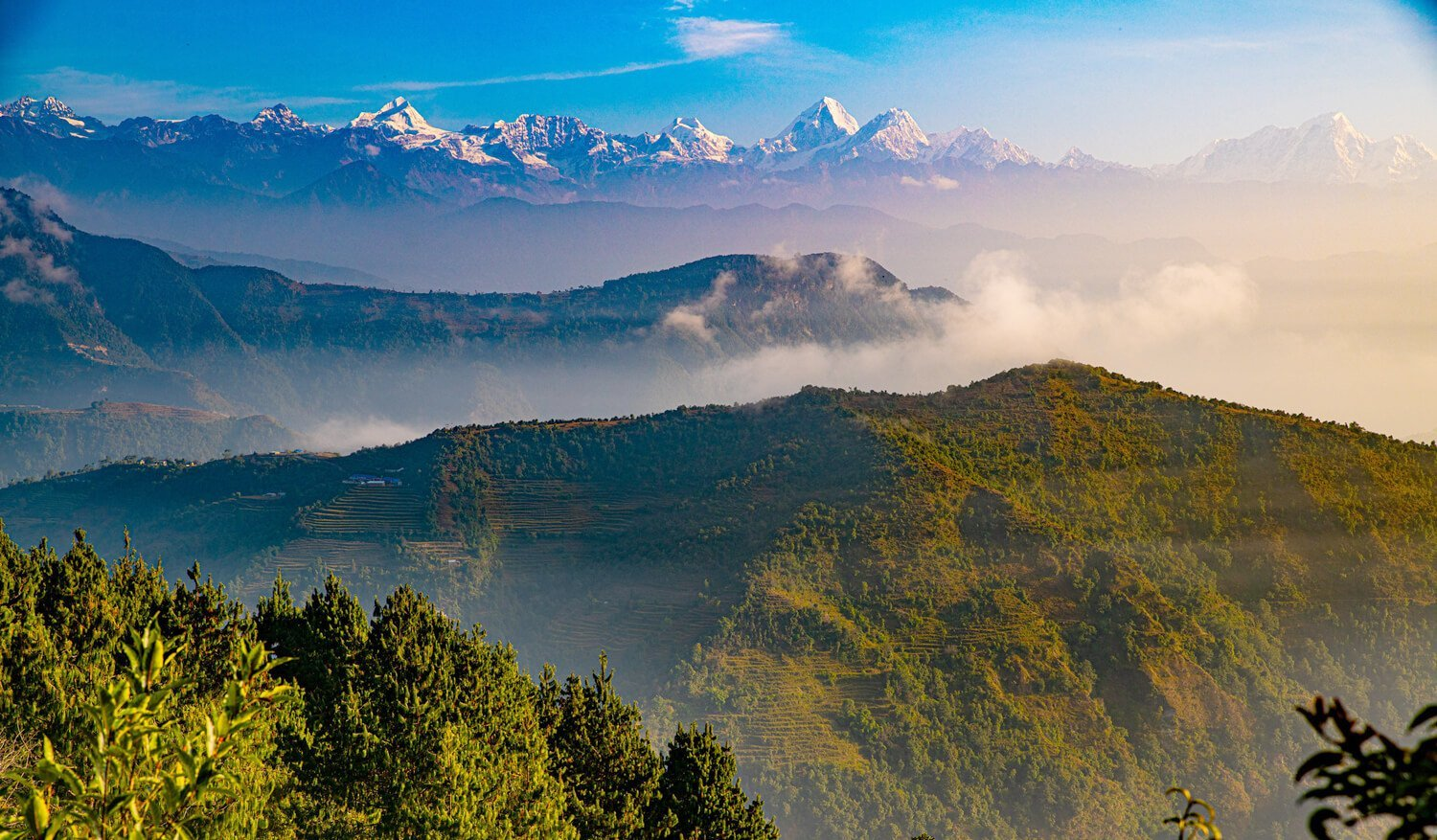 Forest ridges and snow-capped peaks on the Nagarkot to Chisapani trek in Shivapuri National Park